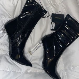 Never been worn. Black leather boots with clear heal.